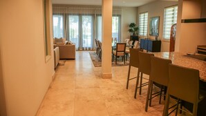 A spacious living area with a kitchen, dining area, and a large window with curtains. - Waking up in a tropical reserve with the sound of the sea caressing your soul. (Río Grande)