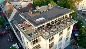 Un edificio de varios pisos con una terraza en la azotea.