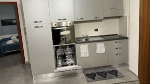 A compact kitchen with a built-in oven, a sink, and a dishwasher.