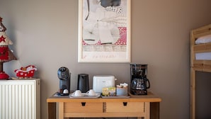 Un coin cuisine équipé d’une machine à café, d’un grille-pain, d’une bouilloire et d’une œuvre d’art encadrée accrochée au mur.