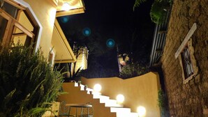 Una scala che conduce a un edificio, con un lampadario in cima.