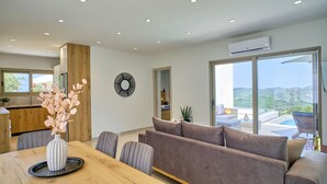 Un salon moderne avec un canapé, une table à manger et une vue sur l’extérieur.