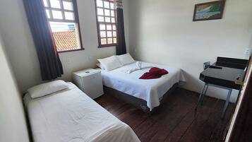A small, tidy room with two single beds, a desk, and a chair.