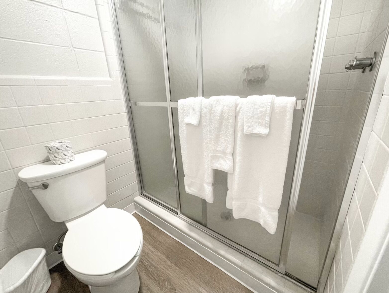 Un baño con inodoro, cabina de ducha y toallero.