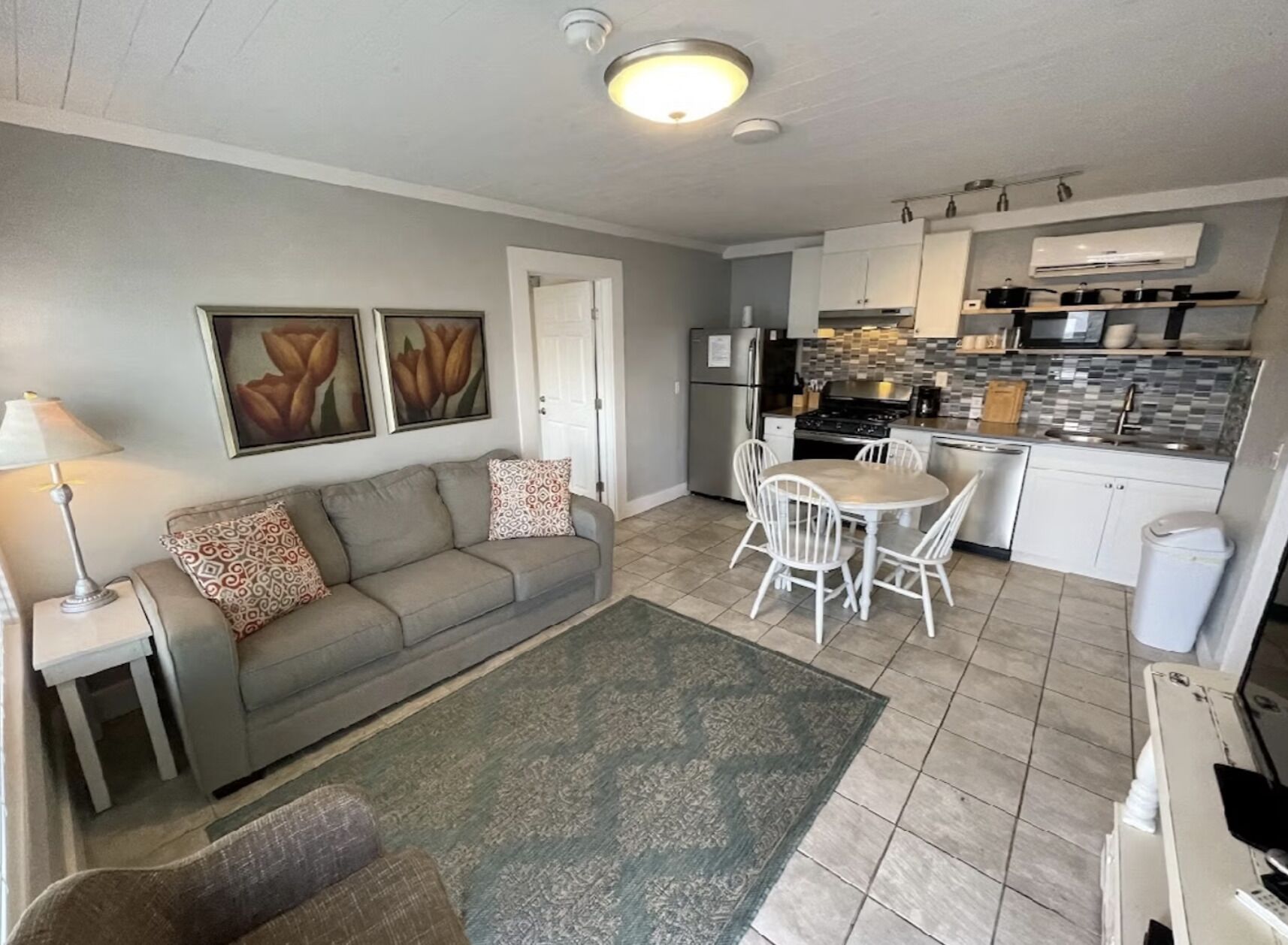 A compact living space with a sofa, dining table, and kitchenette.