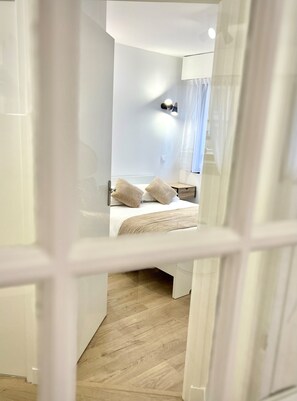Une chambre d’hôtel moderne, équipée d’un lit, de tables de chevet et d’une petite table de nuit.