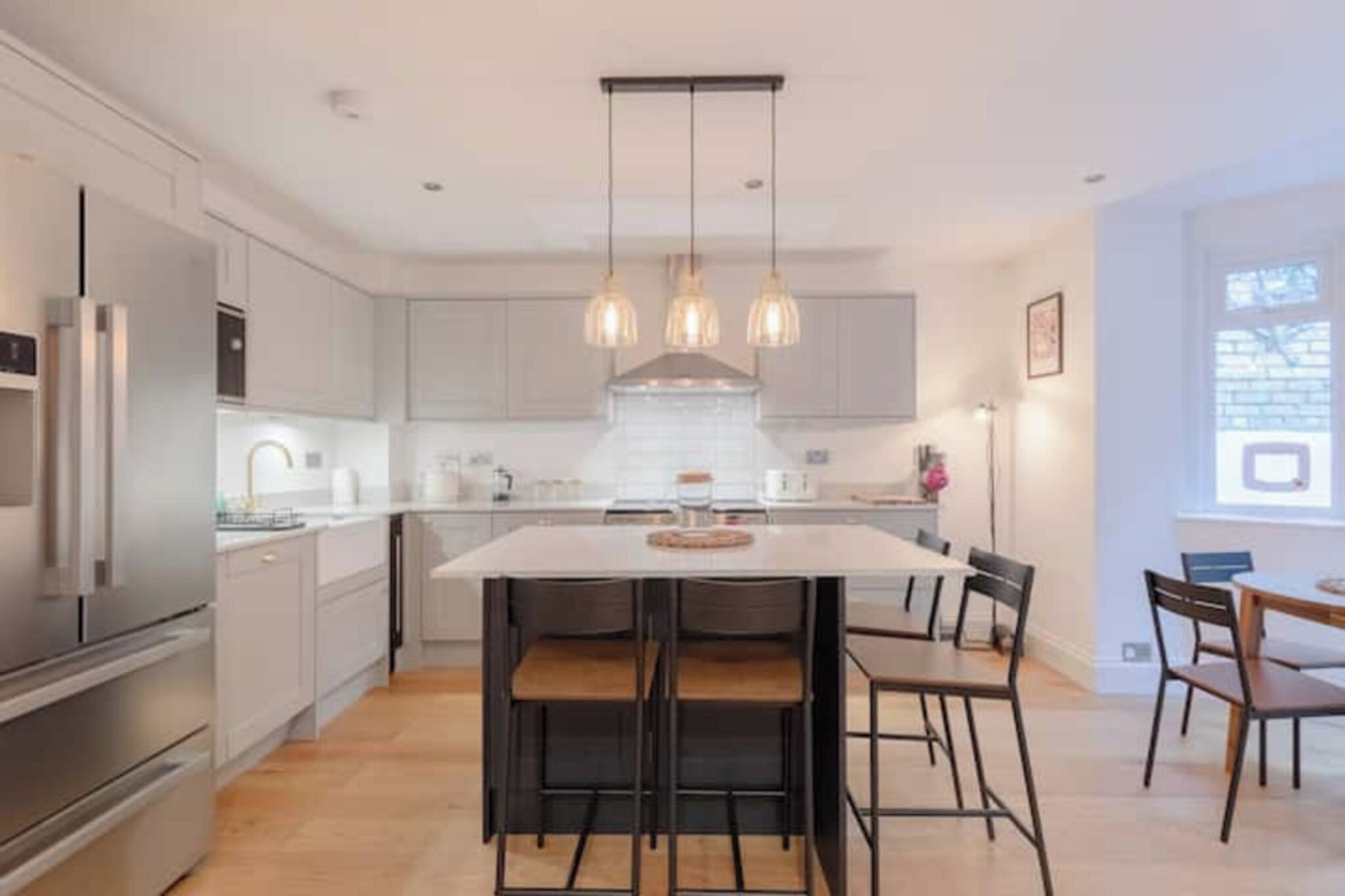 A modern kitchen with a central island, stainless steel appliances, and pendant lighting.