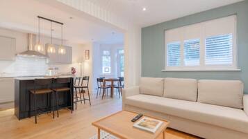 A modern living space with a kitchen, dining area, and a sofa.