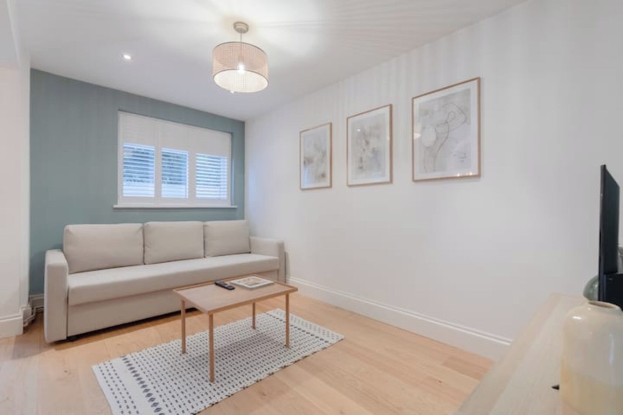 A modern living room with a sofa, coffee table, and artwork on the wall.