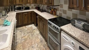 Une cuisine moderne avec des meubles en bois, un four à micro-ondes, une cuisinière et un lave-vaisselle.