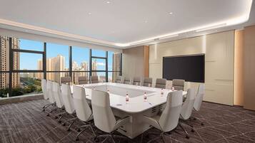 A conference room with a large table, chairs, a projector screen, and a city view.