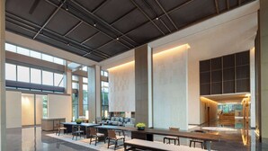 A spacious lobby with a long reception desk, seating area, and a view of the outdoors through large windows. - Wyndham Fuzhou Guian (Fuzhou)