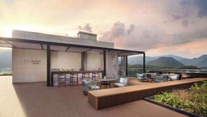 A modern outdoor bar area with seating and a view of mountains. - Wyndham Fuzhou Guian (Fuzhou)