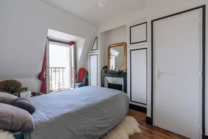 A bedroom with a bed, a dresser, a mirror, and a door.