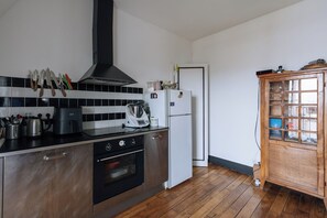 Een keuken met een fornuis, oven en een koelkast.