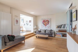 Ein modernes Wohnzimmer mit Sofa, Couchtisch und Bücherregal.
