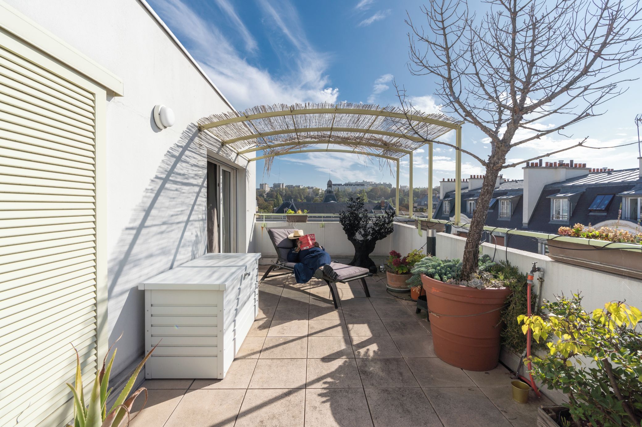A covered outdoor seating area with a view of the cityscape.