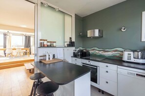 Eine Küche mit schwarzer Arbeitsplatte, weißen Schränken, einem Toaster, einem Wasserkocher und einer Mikrowelle.