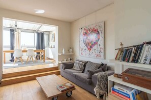 Ein modernes Wohnzimmer mit einer Couch, einem Couchtisch und Bücherregalen.