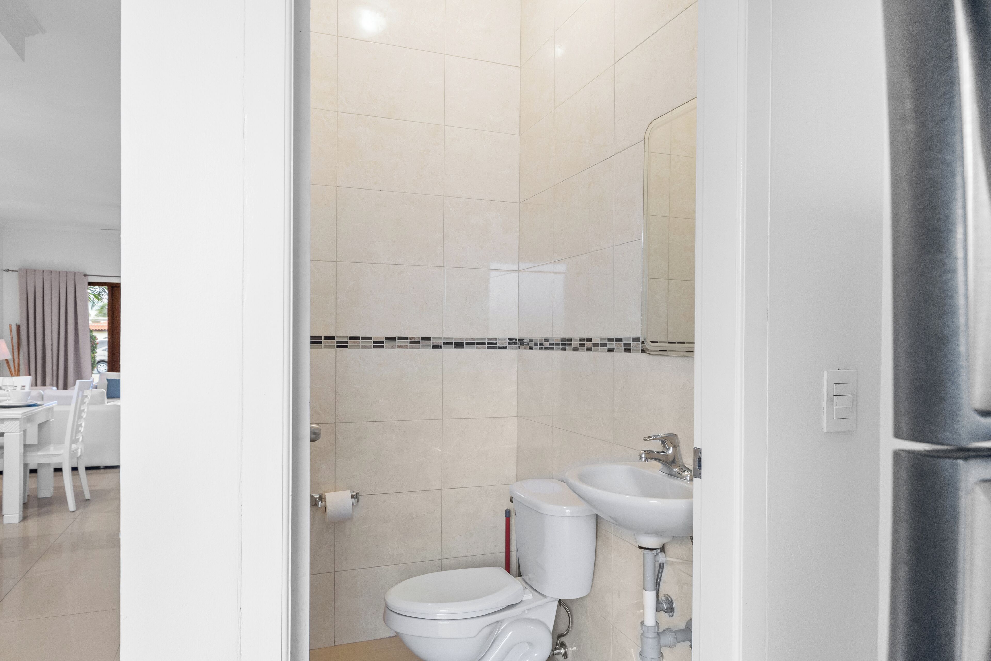 Ein modernes Badezimmer mit Toilette, Waschbecken und Spiegel.