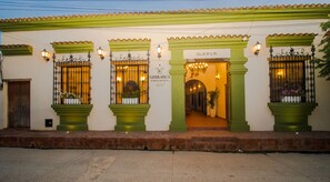 A building with green columns and a sign reading "Literarium Hotel".