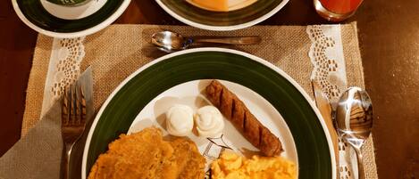 A table with a plate of food, a cup of coffee, and a glass of juice.