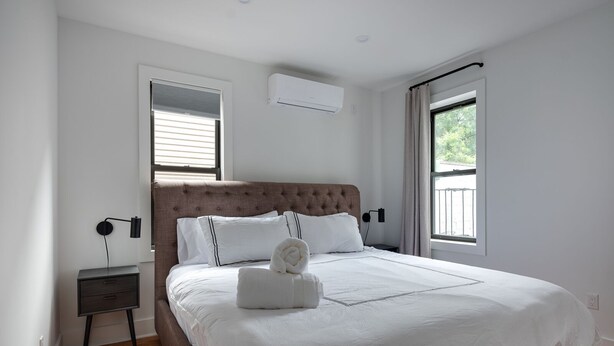 Un dormitorio con una cama grande, una mesita de noche y una ventana.