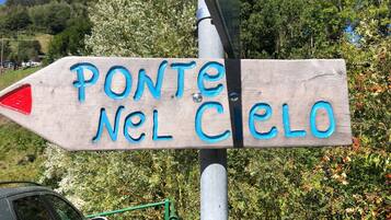 Een houten bord met de tekst 'PONTE NEL Cielo' dat naar rechts wijst.