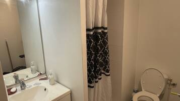 Een douche, handdoeken, zeep, shampoo