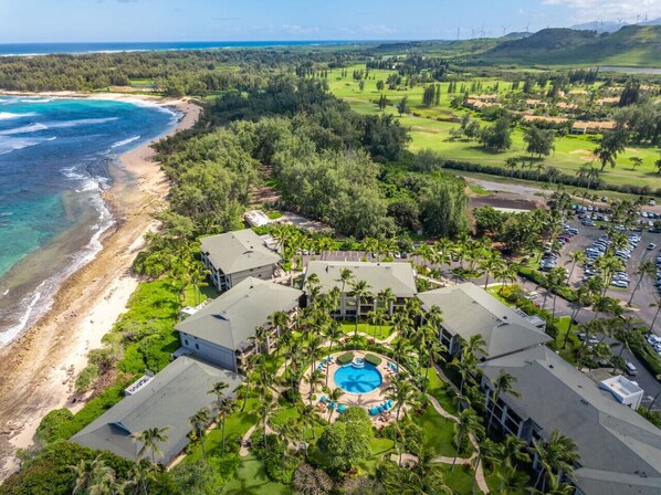 Luftaufnahme eines Resorts mit Schwimmbad, Strandlage und Golfplatz.