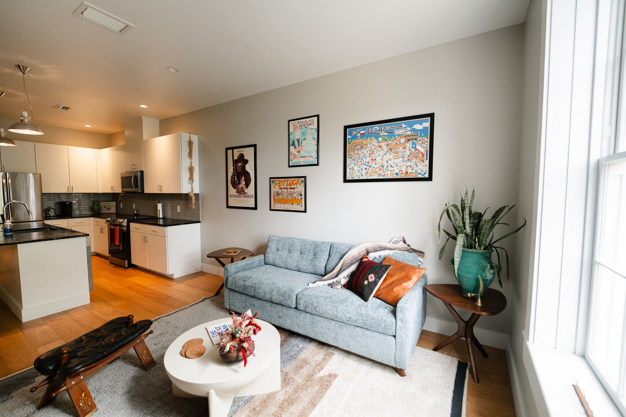 A modern living room with a sofa, coffee table, and artwork on the wall.