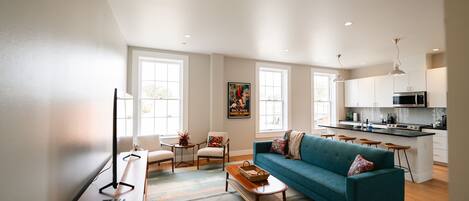 A modern living room with a sofa, coffee table, and a TV stand.
