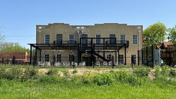 A two-story brick building with a covered outdoor seating area.