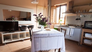 Una cocina moderna con una mesa de comedor, un televisor y un lavabo.