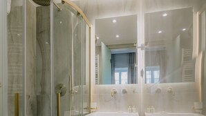 Une salle de bain moderne avec une douche à parois de verre, deux lavabos et un grand miroir.