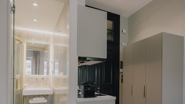Une cuisine moderne avec un plancher en bois, un îlot central intégré et une grande armoire grise.