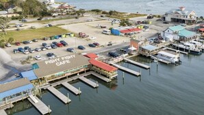 Zona costera con un puerto deportivo, un café de mariscos y un estacionamiento.