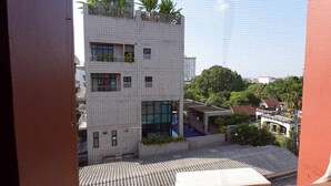 A modern building with a tiled roof, large windows, and a small pool area. - RTW Residence (Bangkok)