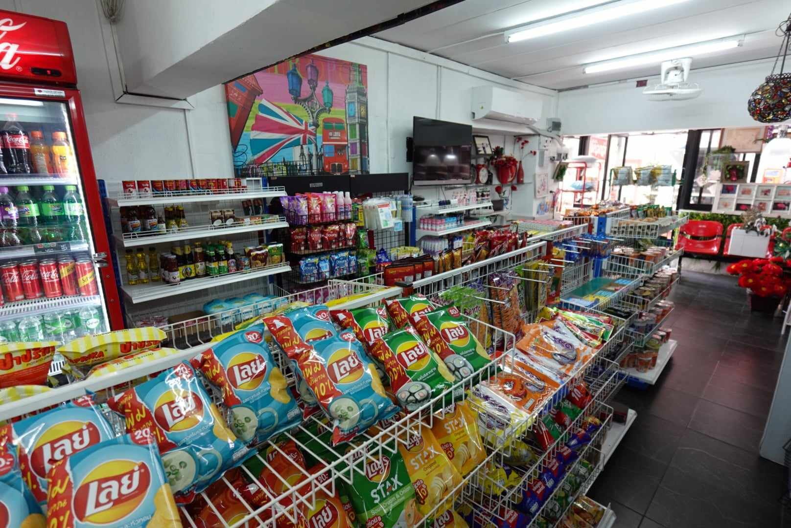 A grocery store with aisles stocked with various products including snacks and beverages.