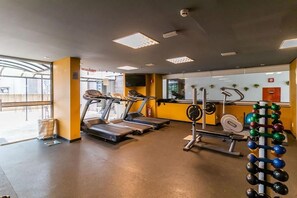 A gym with treadmills, a weight bench, and a rack of dumbbells. - Kubitschek Hotel Flat Particular (Brasília)