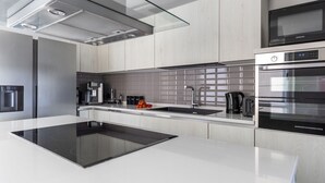 Una cocina moderna con estufa integrada, microondas y cafetera.