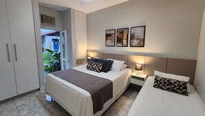 A hotel room with a bed, bedside tables, a wardrobe, and a view of the outdoors. - Angra Temporada (Angra dos Reis)