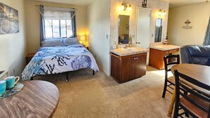A compact bedroom with a bed, bedside table, and a small desk area. - Cozy nautical-themed studio with private entrance (San Diego)