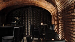 A dimly lit brick-walled interior with tables and chairs arranged for dining. - Casa 63 Hotel Boutique & Spa (San Miguel de Allende)