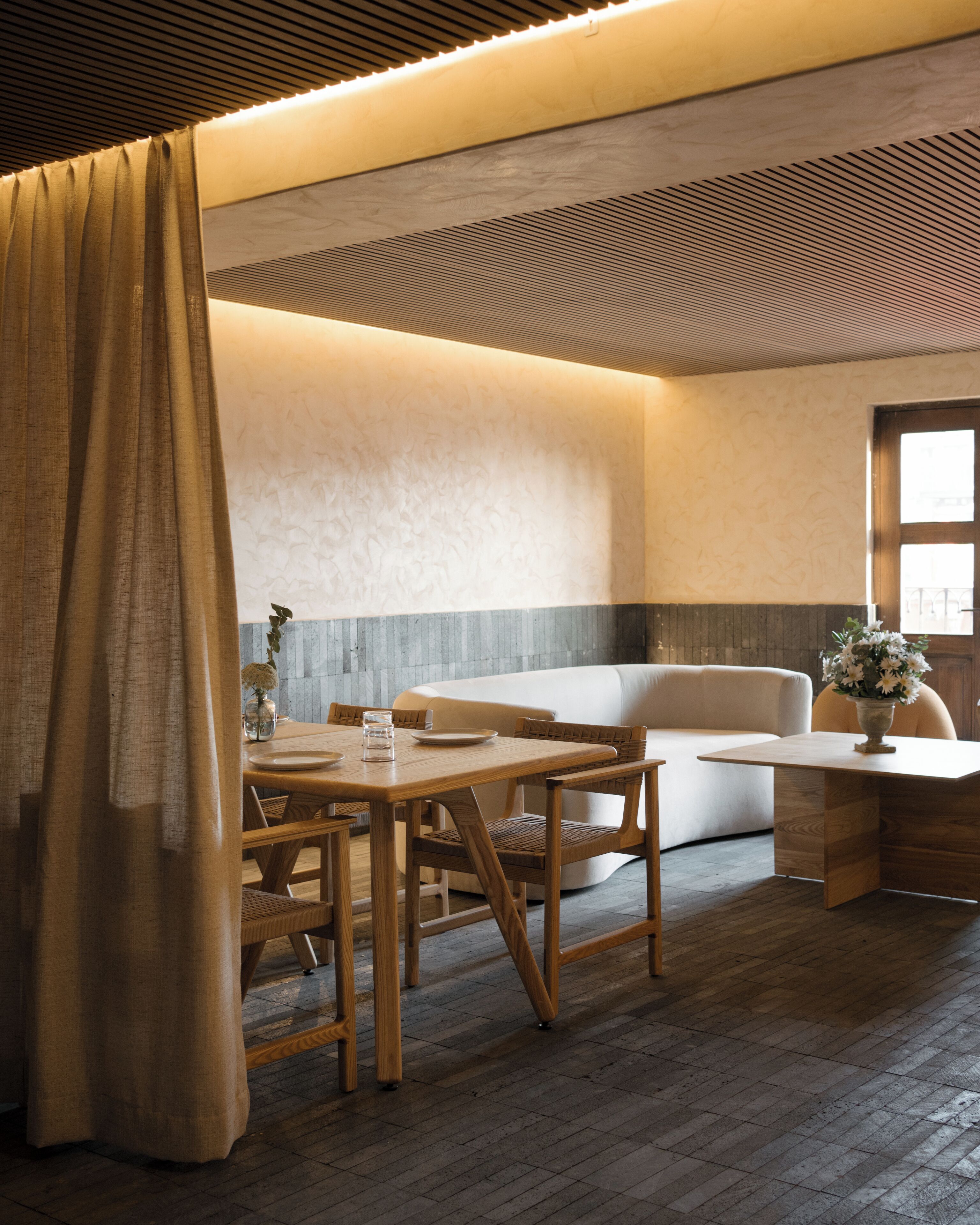 Un interior moderno con comedor, sofá y ventana.