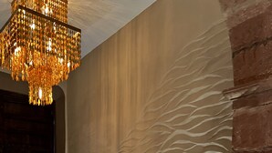 A modern interior with a textured wall, a stone bench, and a decorative chandelier. - Casa 63 Hotel Boutique & Spa (San Miguel de Allende)