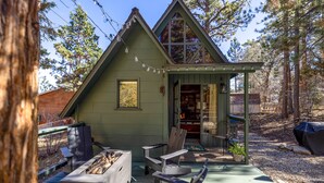 Une cabane dotée d’une terrasse, d’un foyer extérieur et de sièges pour profiter de l’extérieur.