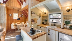 L’intérieur chaleureux d’un chalet comprend un coin repas, une cuisine et une grande fenêtre.