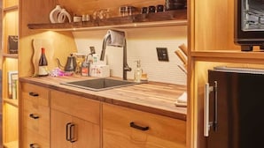 Une cuisine moderne avec des meubles en bois, un réfrigérateur en acier inoxydable et un four encastré.
