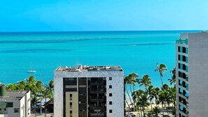 A multi-story building with a view of the ocean and palm trees. - Edifício Time (Maceió)